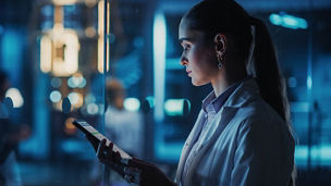 Woman in lab attire on device