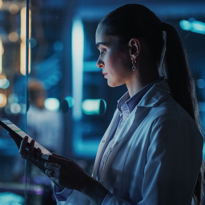 Woman in lab attire on device