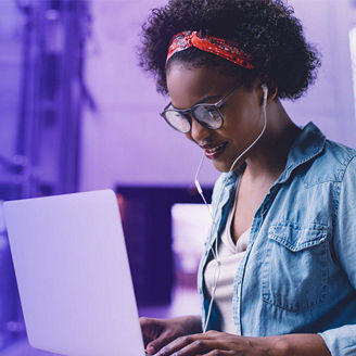 Vrouw achter laptop met oortjes in