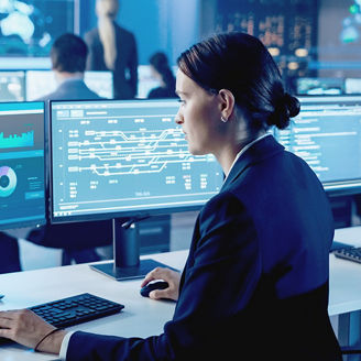 Woman looking at multiple computer monitors