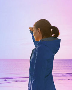 Woman on beach looking towards sun, horizon, healthcare, horizons
