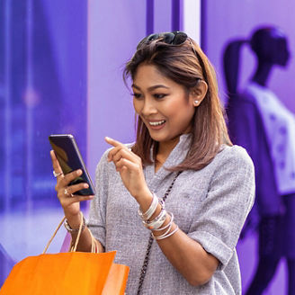 Woman online shopping outside retail store