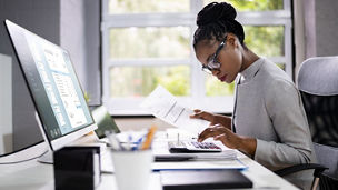A woman ensuring accuracy through efficient invoice review.