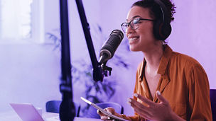 Woman recording podcast with tablet in her hand