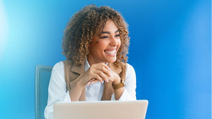 Woman sitting at meeting table with laptop and smiling