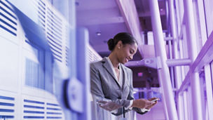 Woman in suit smiling at phone