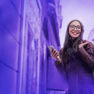 woman using smartphone and looking away while enjoying a day shopping