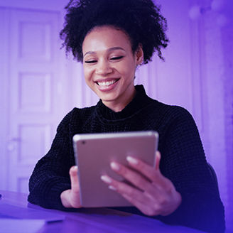Happy female student freelancer laughs while working on a computer gadget