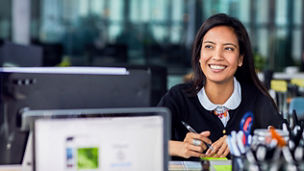 woman smiling while writing