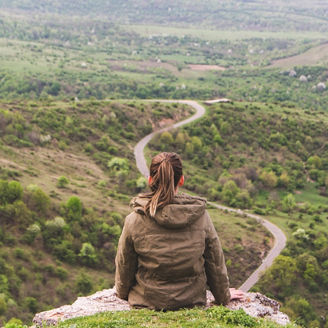 woman standing on mountain road