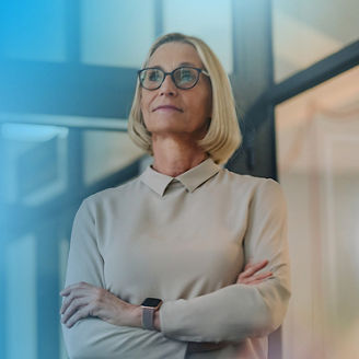 Woman standing with arms crossed in a modern office