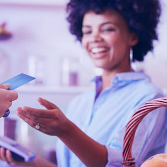 Shot of a female juice bar owner taking payment from customer. Female customer paying for juice with credit card.