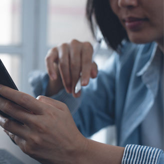woman using phone while working on laptop banner