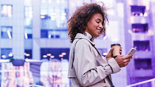 woman using phone whilst drinking coffee