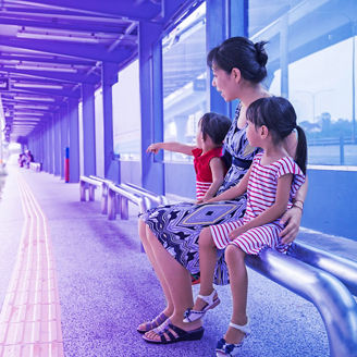 Woman waiting with children on the bus stop
