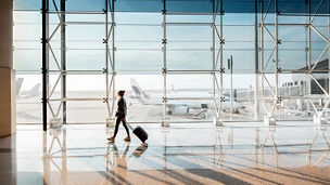 Woman walking through the airport carrying suitcase