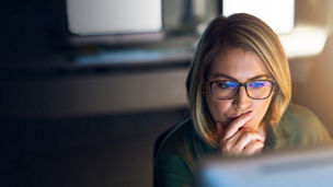 vrouw met bril kijkt naar computerscherm