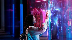 Woman with backpack touching holographic retail display