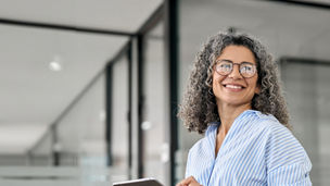 Woman with Glasses Smiling Sideways Holding Tablet