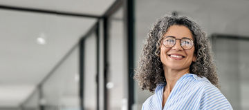 Woman with Glasses Smiling Sideways Holding Tablet