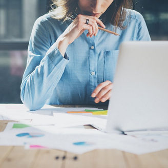Woman working laptop papers on desk