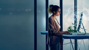 Person working at a computer with a digital network and globe visualization.