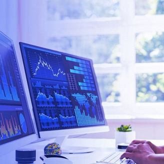 Woman working on multiple computer screens