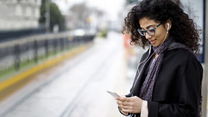 Woman listening to music from phone via earphone