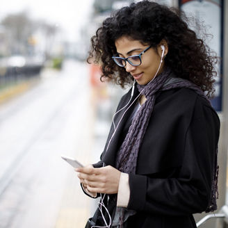 Woman listening to music from phone via earphone