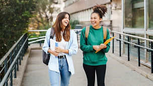 women walking and laughing with books
