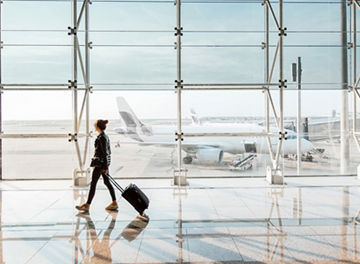 Women walking on airport with a bag