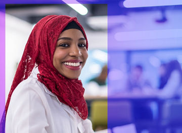 Young modern black muslim business woman wearing a red hijab,working on laptop computer in startup office. Diversity, multiracial concept