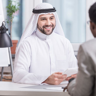Arabian businessman smiling and holding digital tablet in office 