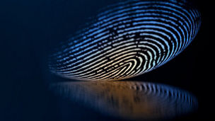 Glowing fingerprint with reflection on dark background