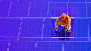 Werker staat op zonnepanelen
