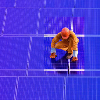 Werker staat op zonnepanelen