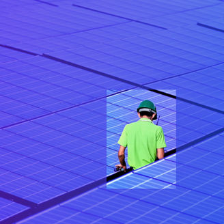 Werker loopt tussen zonnepanelen.