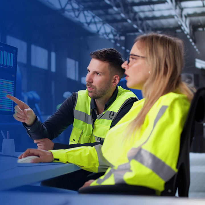 Workers in safety vests using computer