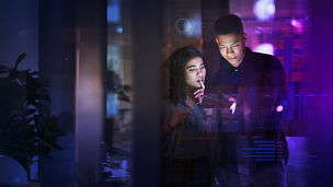 Workers using AI on a digital tablet in the office at night