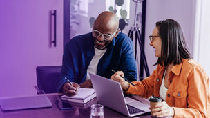 Man and woman laughing and working together