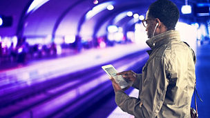 young man looking at his phone at a station