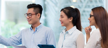 Youngbusinessman explaining chart on the whiteboard to his colleagues