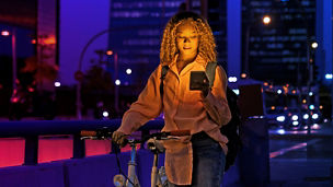 vrouw met haar fiets aan de hand op telefoon aan kijken 