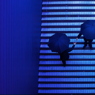 two people under umbrellas shake hands