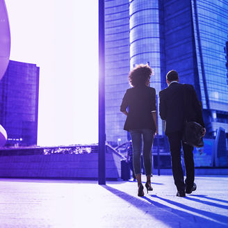 Zwei Personen von hinten vor Gebäude